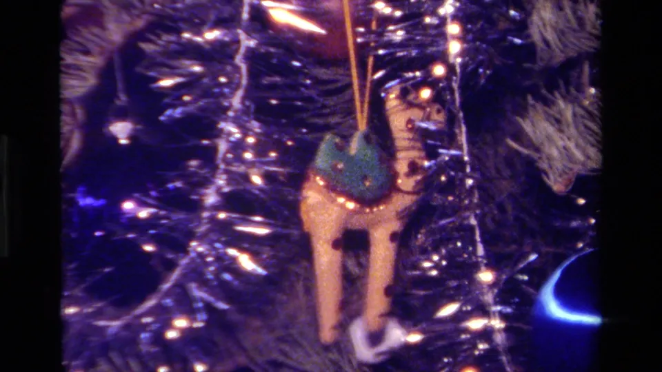 1979 California 8mm close-up of a small rocking horse ornament against tinsel and Christmas tree branches.