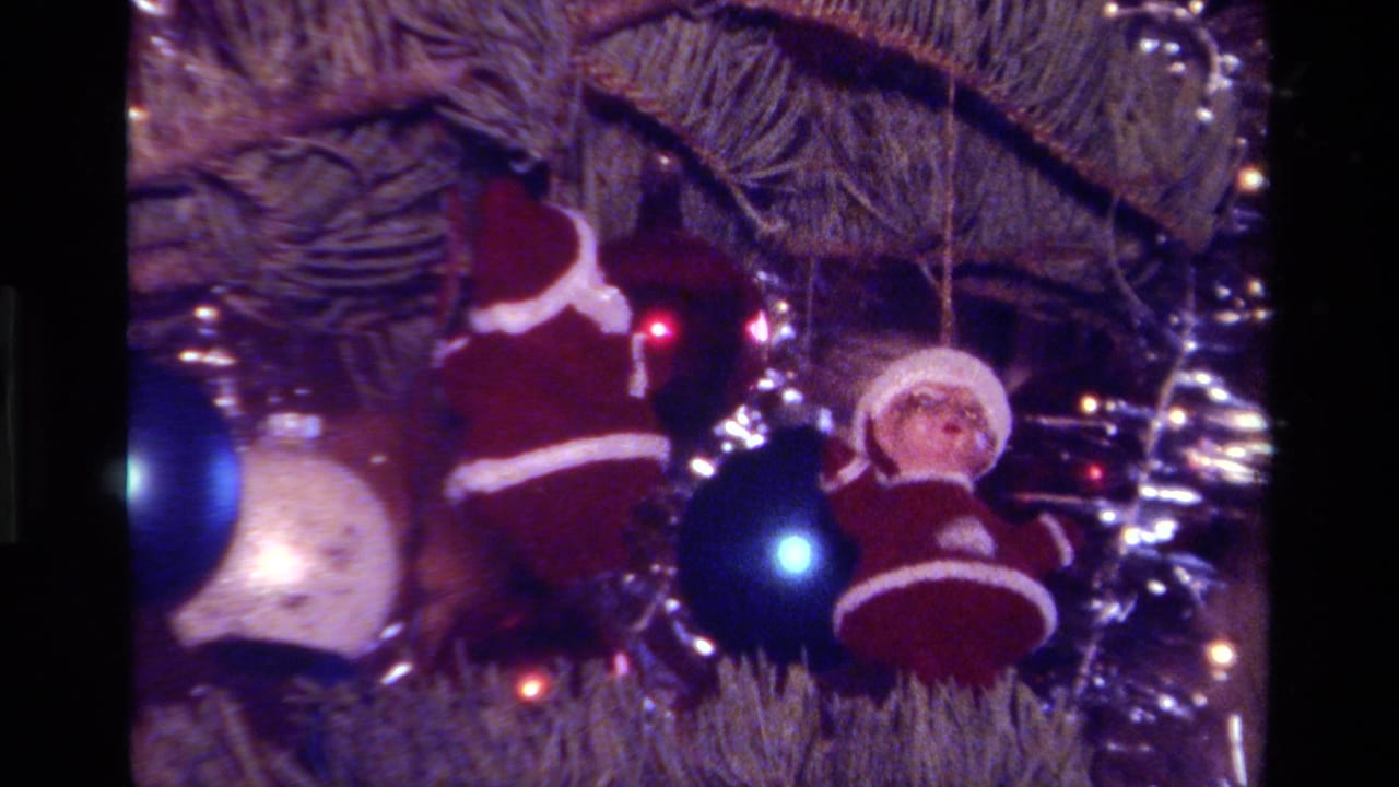 1979 California home-movie still of red-and-white Santa ornaments near blue and silver decorations on a lit Christmas tree.