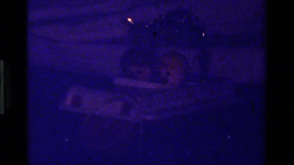 Dark blue end frame from the 1979 California 8mm clip, with a faint outline of the toy car still visible.