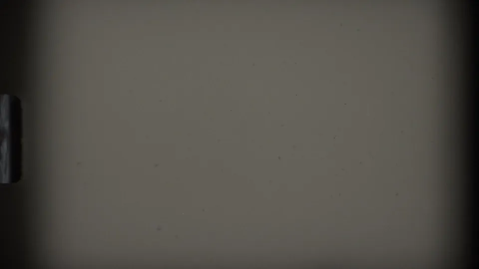 A mostly obscured 8mm frame from the contact sheet, showing a pale surface and dark film edge with no clear subject visible.