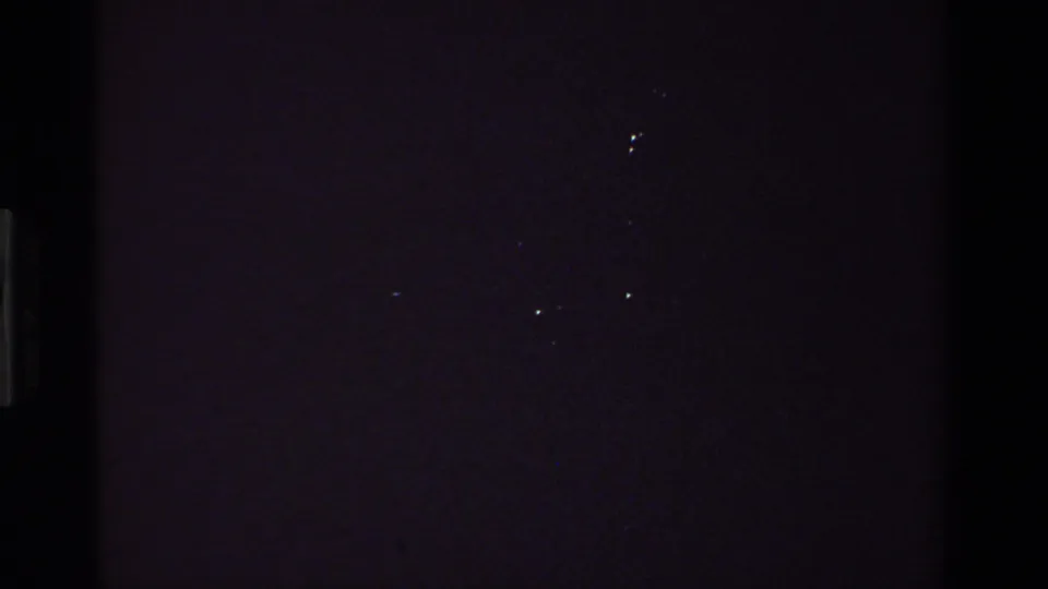 Underexposed opening frame from a 1981 8mm California home movie, with only faint film specks and dark interior tones visible.