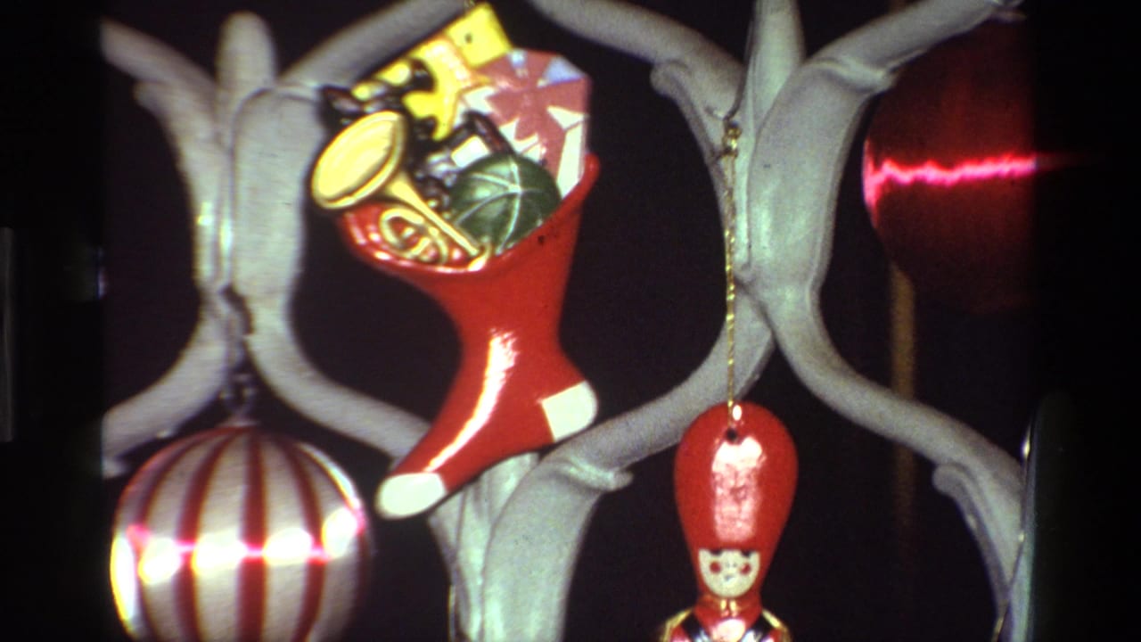 1981 California 8mm frame showing a red toy-filled stocking ornament among pale green branches, striped ball ornament, and red soldier figure.