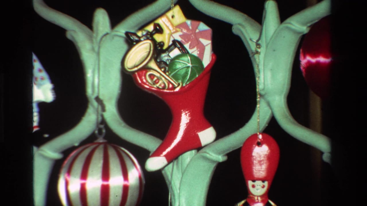 1981 California holiday frame with a toy-filled red stocking, striped ball ornament, soldier figure, and pale green branch structure.