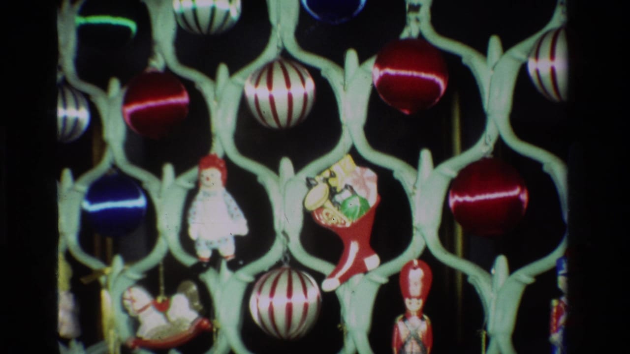 1981 California 8mm frame showing red, blue, and striped Christmas baubles with small figurines on a pale green lattice stand.