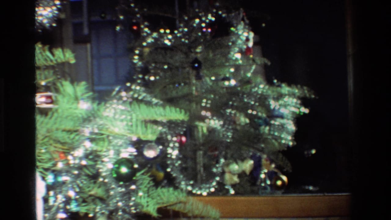 A small Christmas tree with silver tinsel and reflective ornaments appears inside a California home in the 1981 8mm footage.