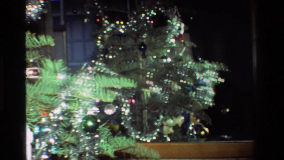 A small Christmas tree with silver tinsel and reflective ornaments appears inside a California home in the 1981 8mm footage.
