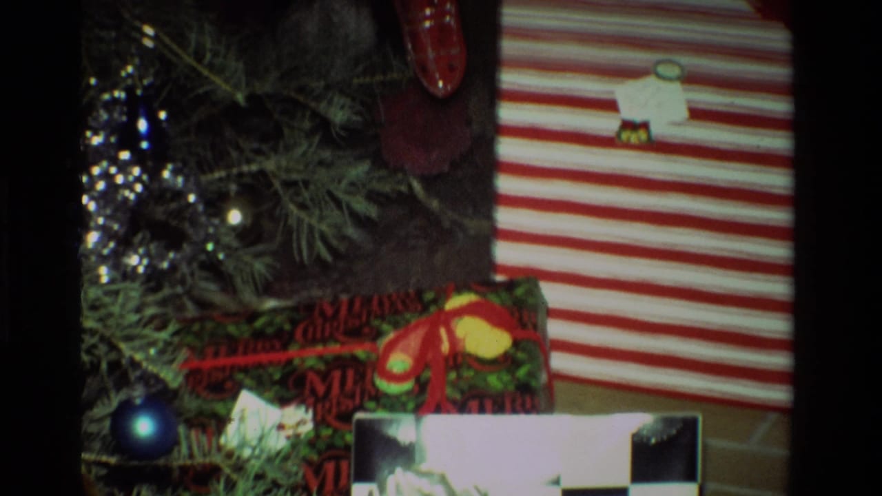 1981 California holiday decor with tree branches, shiny ornaments, tinsel, festive wrapping, and a striped gift package.