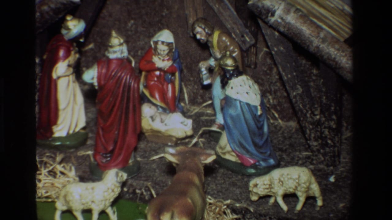 Closer 1981 8mm view of the California nativity display, centering the manger while Mary, Joseph, wise men, sheep, and stable materials remain visible.