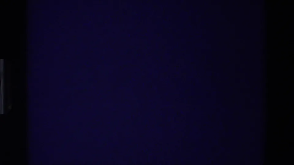 Nearly dark 8mm frame with a blue cast and minimal visible detail, likely at the end of the nativity shot.