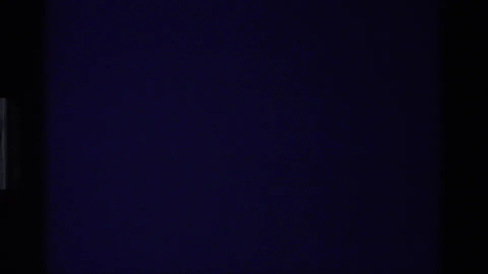 Dark opening frame from the 1981 California 8mm clip, with little visible detail and a blue-tinted film area.