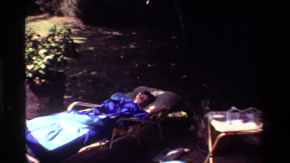 Final 1981 California frame shows the person still resting on the chaise lounge, with a blue blanket, pillow, side table, and shaded yard visible.