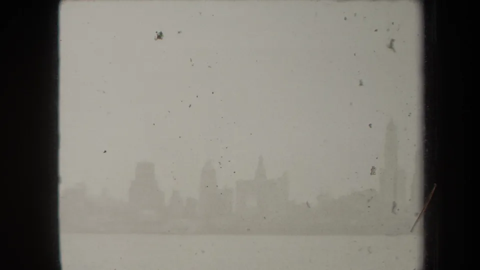 The skyline remains low and faint across the river, with scratches, dust, and soft exposure from the 8mm source.