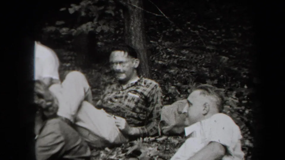 1938 New York wooded gathering with adults sitting close together and conversing in candid home-movie footage.