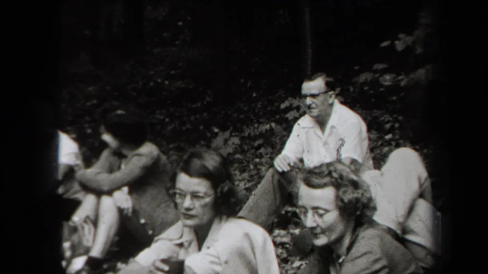 1938 New York candid outdoor scene with adult friends seated in a wooded area, smiling and talking.