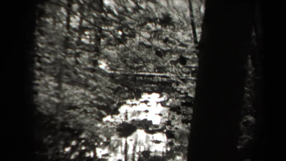 1938 New York 8mm frame showing a small woodland waterfall or stream through dark film borders.