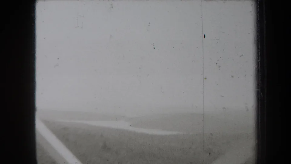 1938 New York 8mm frame with fog over open land and a pale diagonal line that may be a road, riverbank, or water edge.