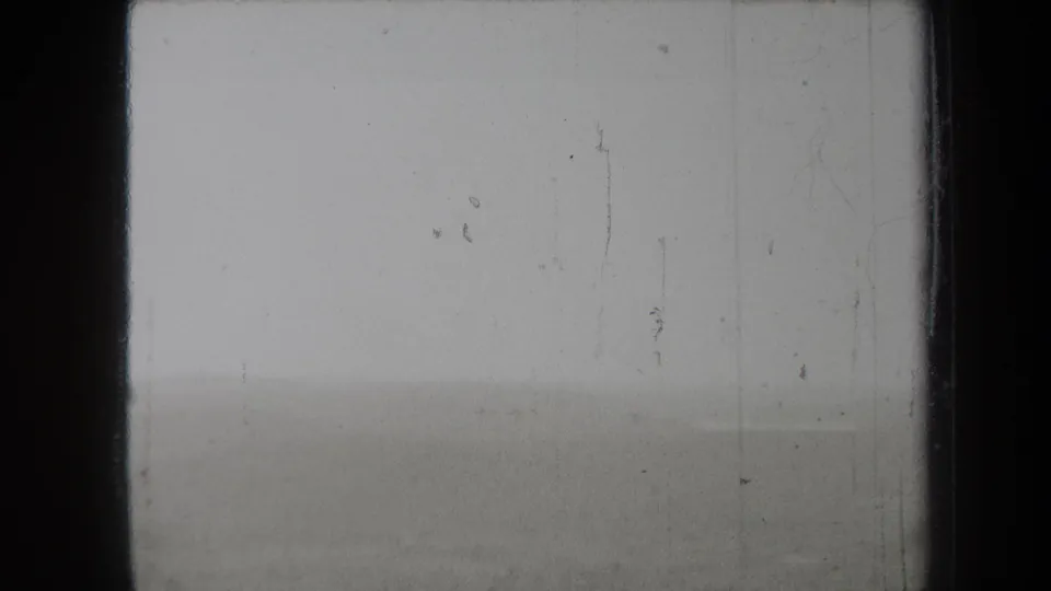 1938 New York 8mm frame with a nearly washed-out foggy landscape, faint distant line, and prominent film dust and scratches.