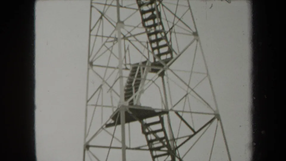 1938 New York home-movie frame of a tall metal observation tower, centered on stair flights and landings.