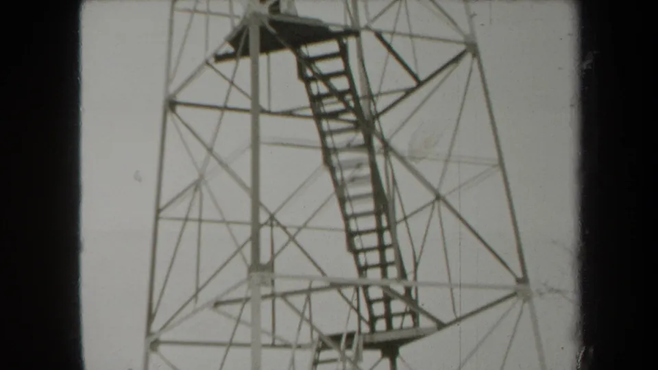 1938 New York 8mm frame showing the lower observation tower with stairways and a faint person near the base.