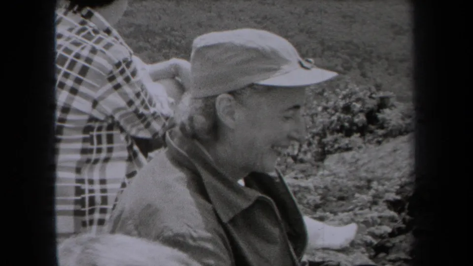 Smiling older woman in a cap sits beside a plaid-clad companion during a 1938 New York family outing.