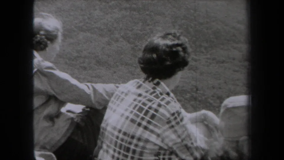 Family members sit with their backs to the camera, looking outward from a grassy New York overlook in 1938.