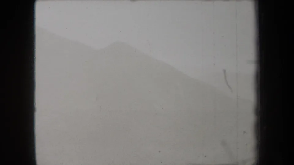 A soft, fog-covered hillside appears in this 1938 New York 8mm frame, with a faint ridge line and visible archival film texture.