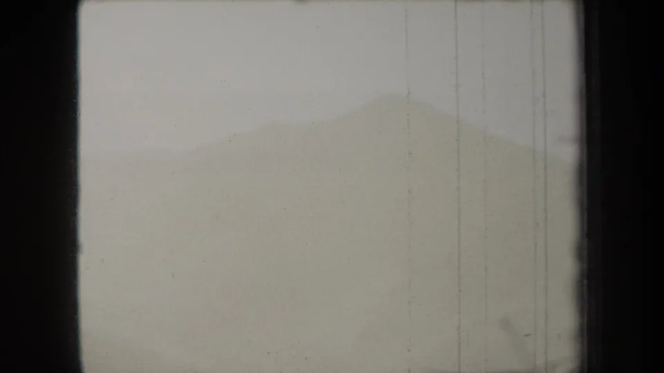 1938 New York 8mm frame with a distant hazy ridge, soft grey exposure, dark side borders, and visible vertical scratches.