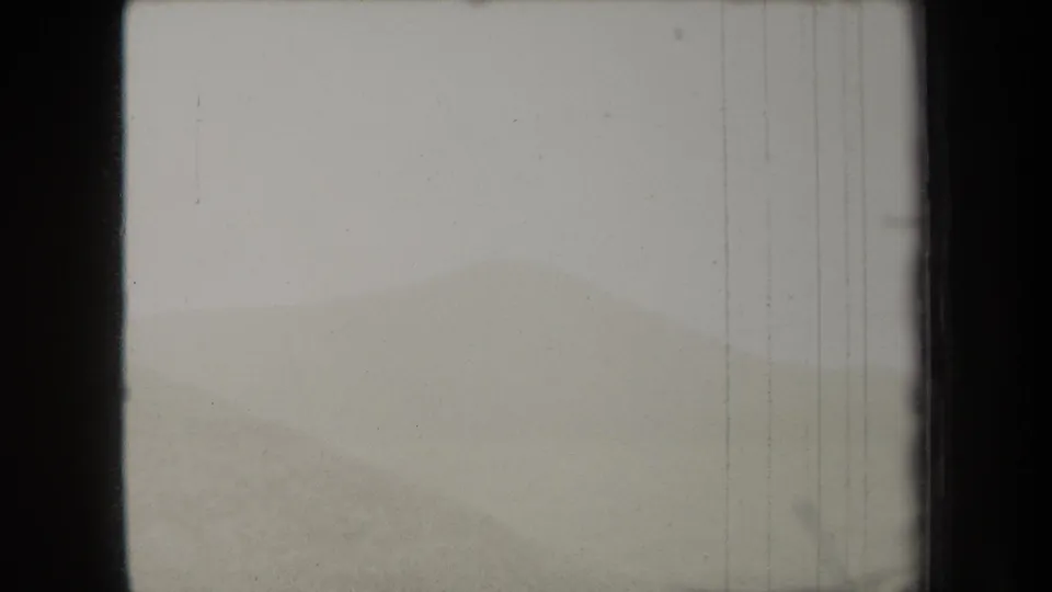 1938 New York 8mm home-movie frame showing pale fog over rolling green hills with visible film grain and border wear.