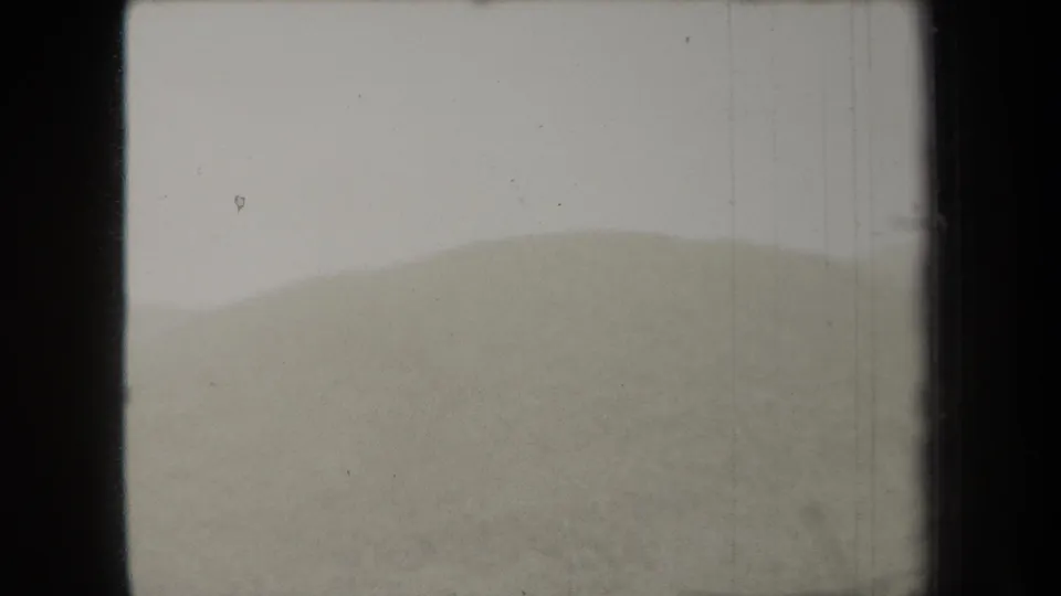 1938 New York 8mm frame showing low rolling dunes or small hills with a soft horizon and visible film wear.