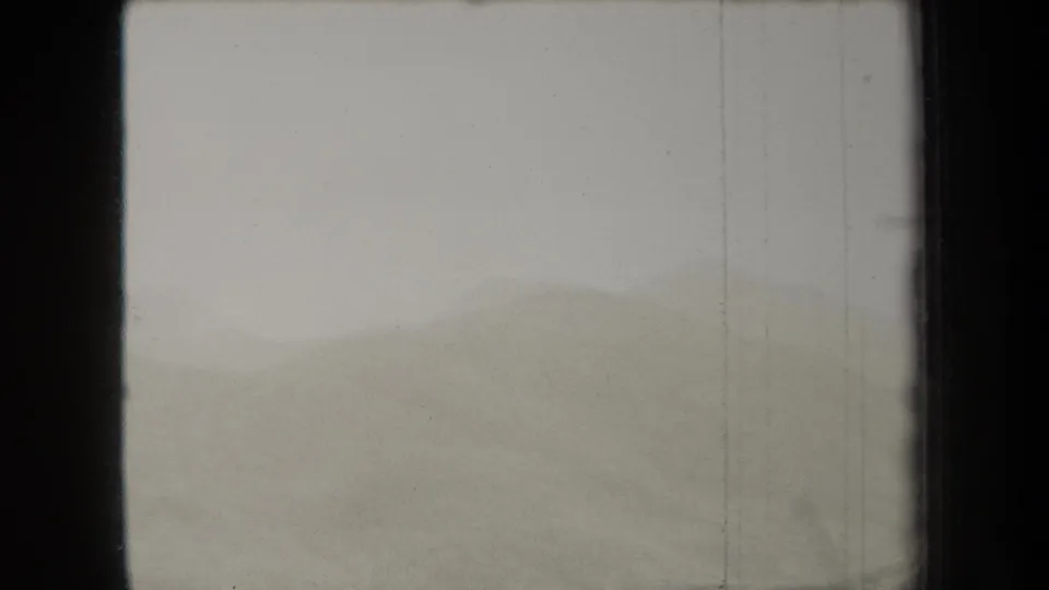 A static 1938 New York landscape frame with muted hills fading into fog and visible vertical film wear.