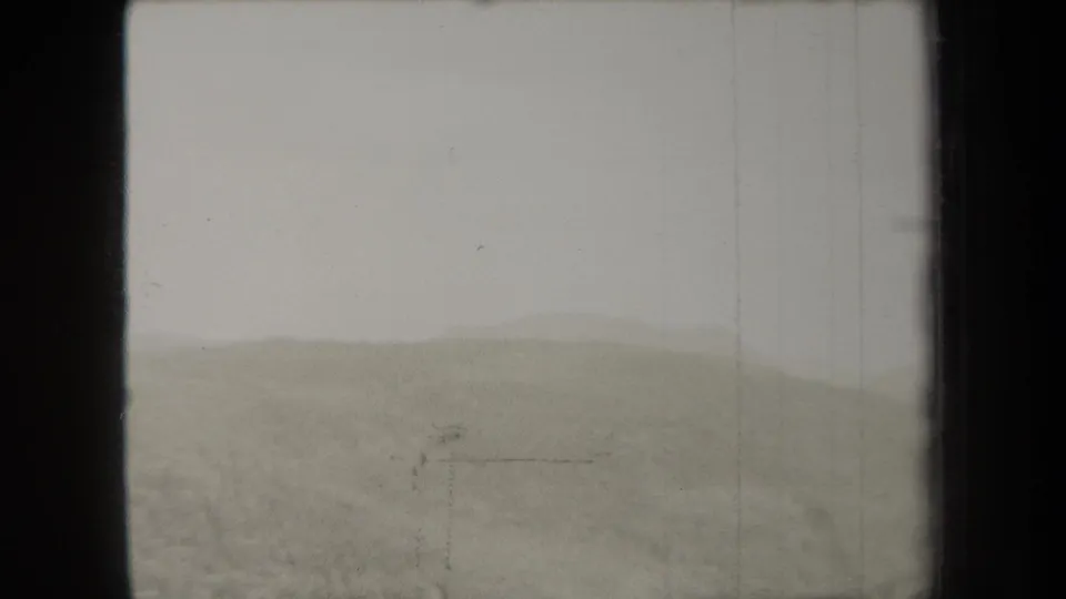 1938 New York 8mm landscape frame with a misty ridge line, muted sky, and visible dust and scratches from the film scan.