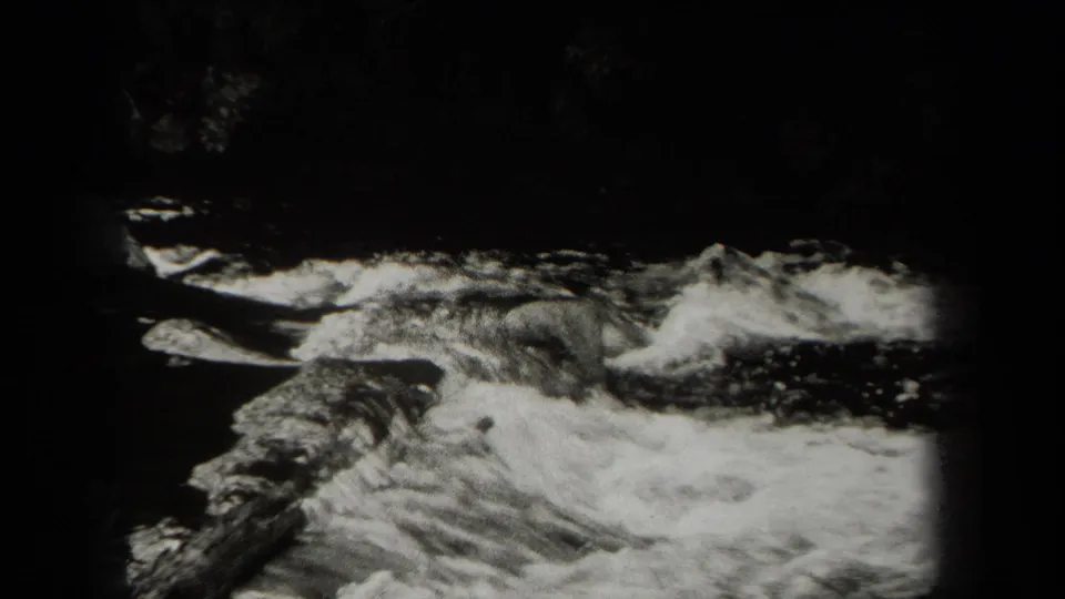 A final 1938 New York home-movie frame shows fast-moving river water over rocks, with soft focus and heavy film borders.