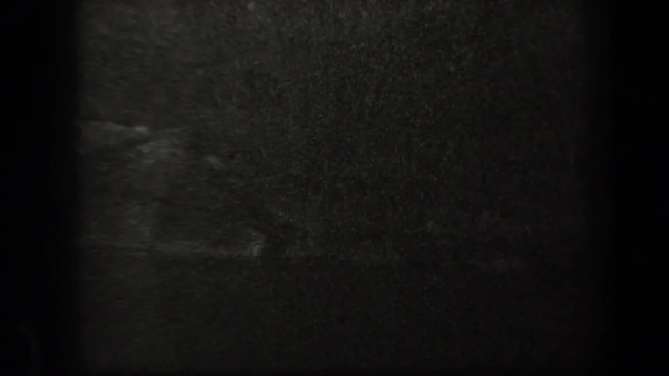 The final 1938 New York 8mm frame is mostly dark and grainy, with little readable subject detail beyond faint texture and exposure falloff.