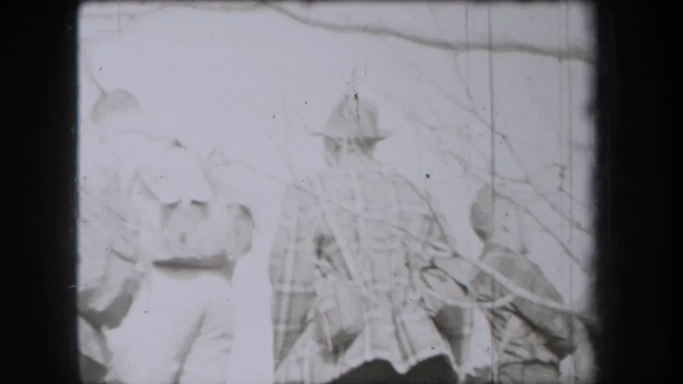 A group of hikers in 1938 New York appears behind bare branches, with hats and layered clothing visible despite heavy exposure.
