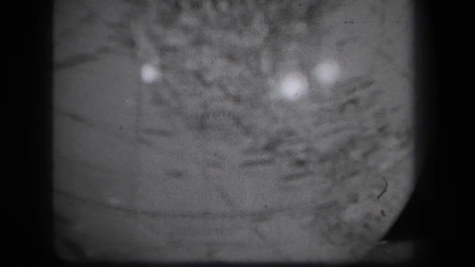 1939 8mm New York footage showing a blurred close view of a globe surface with light reflections, grain, and gate edges.