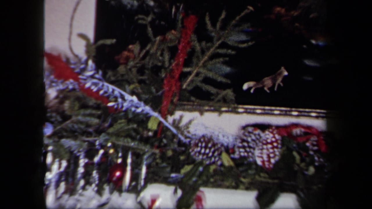 Decorated mantel with greenery, pinecones, tinsel and small animal figures.