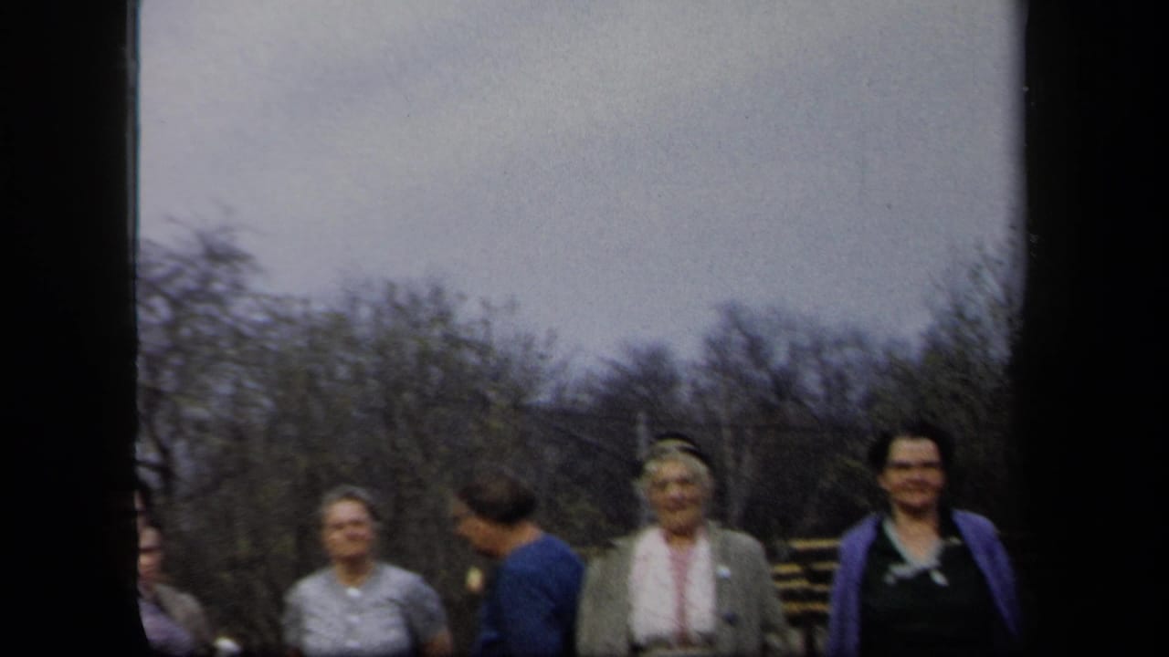 Women in 1950s-style clothing appear in a New York outdoor yard scene, with bare trees and a partly obscured contact-sheet frame.