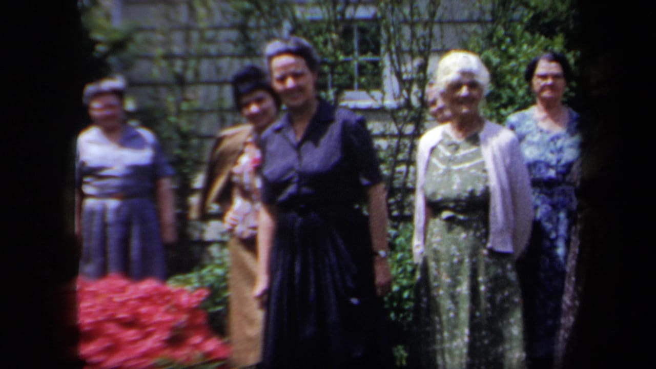 Group of older women standing together in a sunny garden.