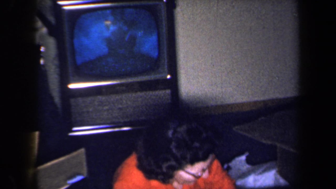 Television screen glows blue while the woman leans partly out of frame.