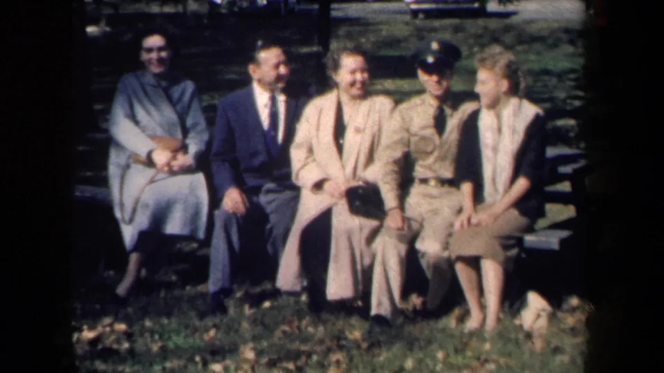 The bench group smiles and converses in a sun-dappled New York park scene from 1959 home-movie footage.