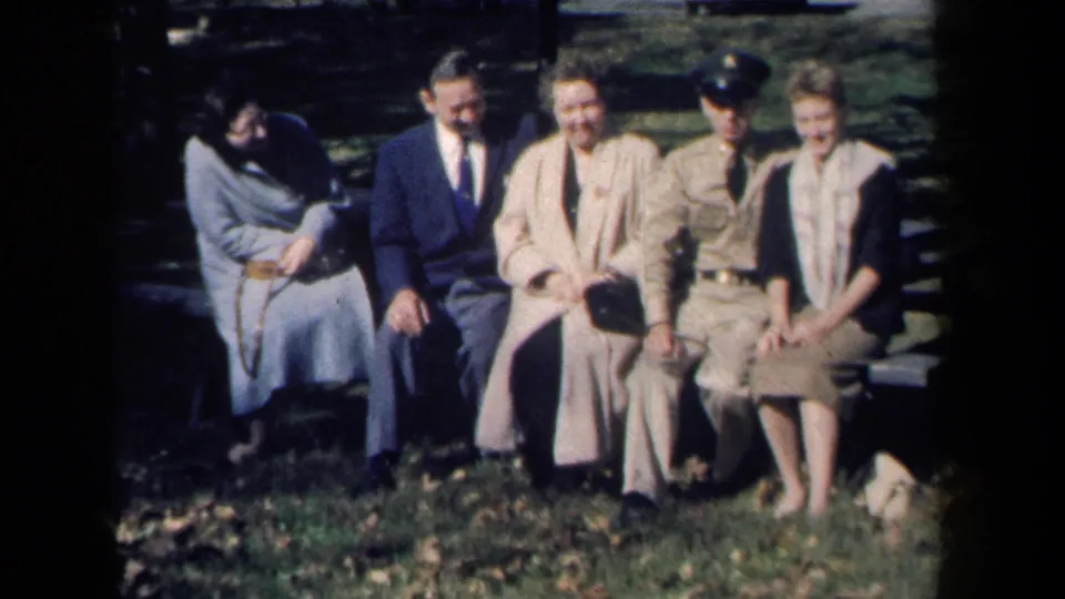 A brief motion shift shows one woman leaning down while the rest of the 1959 New York bench group remains seated toward the camera.