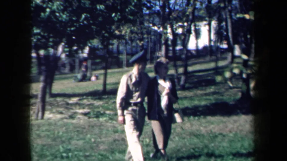 Near the end of the 1959 New York park clip, the couple passes close to the camera, still arm in arm amid trees and grass.