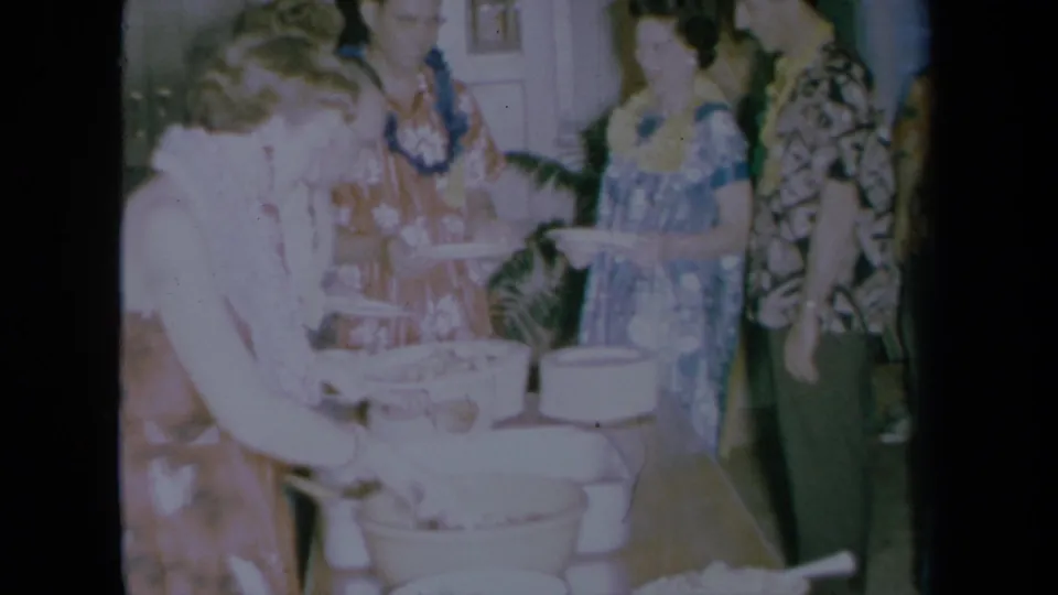 A candid 1961 party moment shows a guest serving food from buffet bowls as other adults in leis and patterned clothes stand nearby.