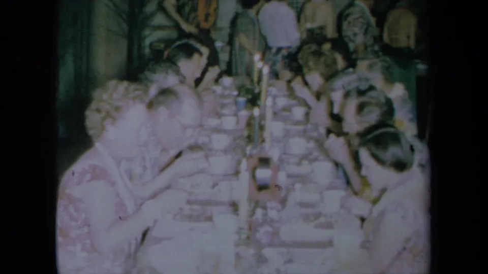 Final frame shows adults at a long rectangular dining table in a 1961 California home-movie scene.