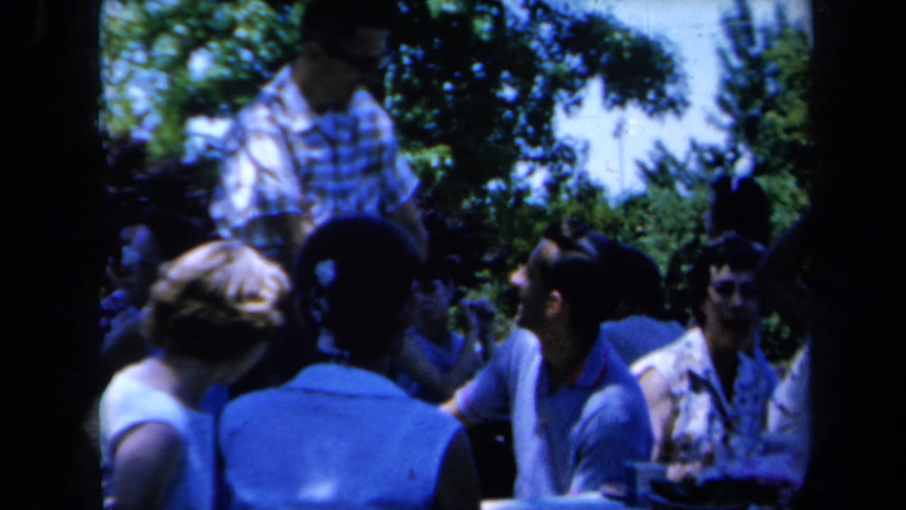 Adults in summer clothing socialize under leafy trees in 1961 California home-movie footage.