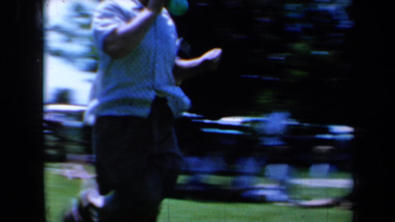 A close, motion-blurred view shows an adult participant running past the camera in the 1961 California outdoor game footage.