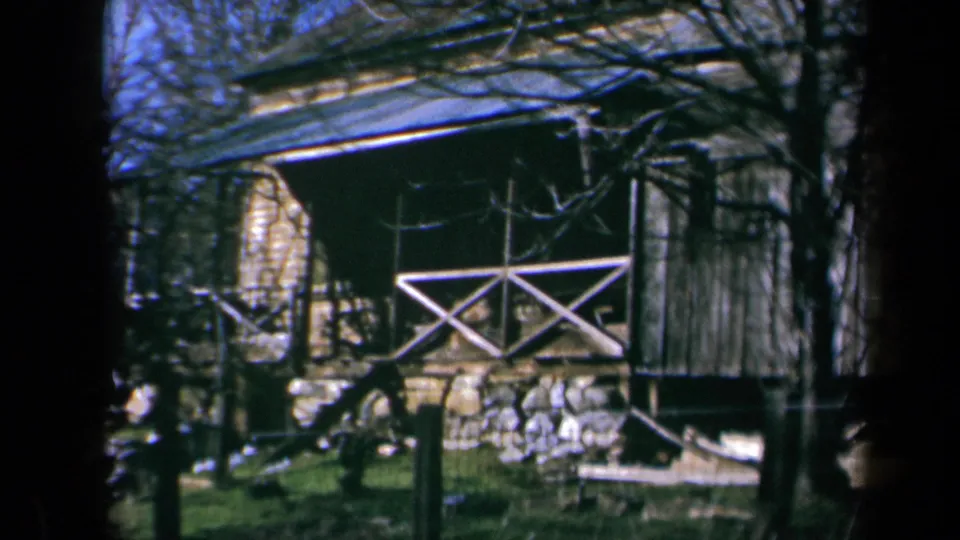 The final frame centers on a rustic California outbuilding with a corrugated roof, porch railing, stone base, and surrounding trees.