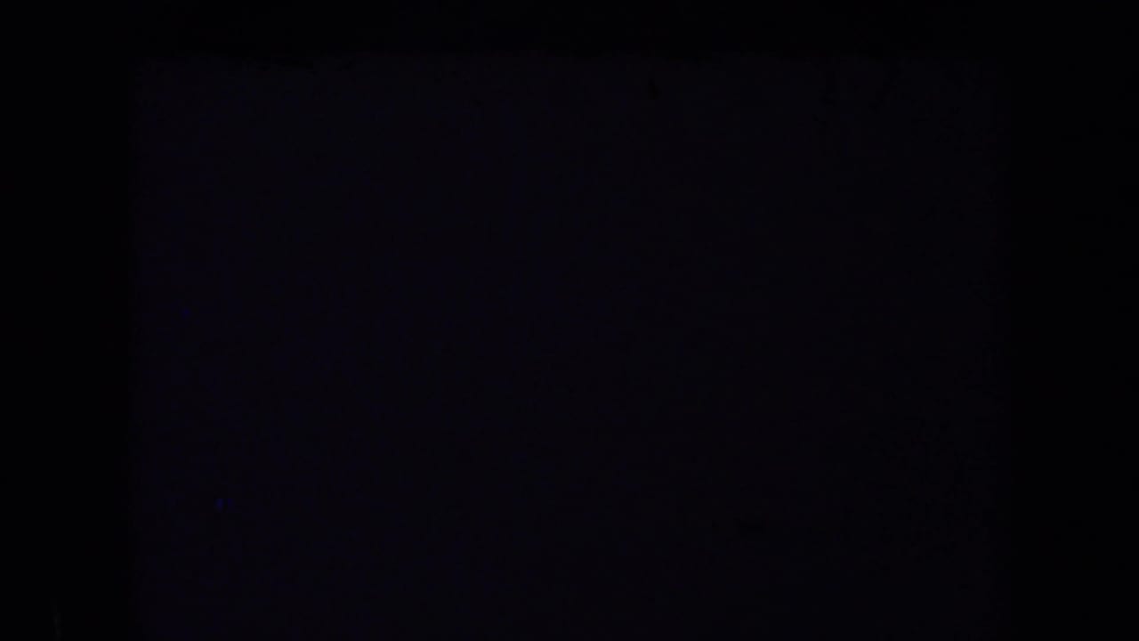 A mostly dark 8mm frame from the 1969 California home-movie clip, with only faint edge tone visible.