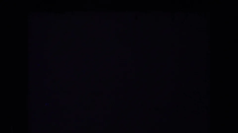 A mostly dark 8mm frame from the 1969 California home-movie clip, with only faint edge tone visible.