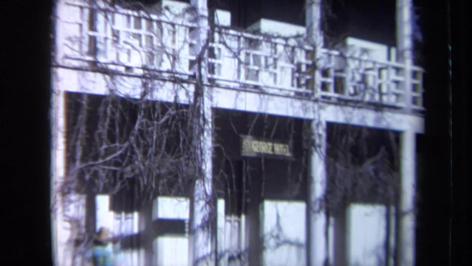 California hotel facade with balcony railings, windows, bare branches, and a partially visible St. George Hotel sign.